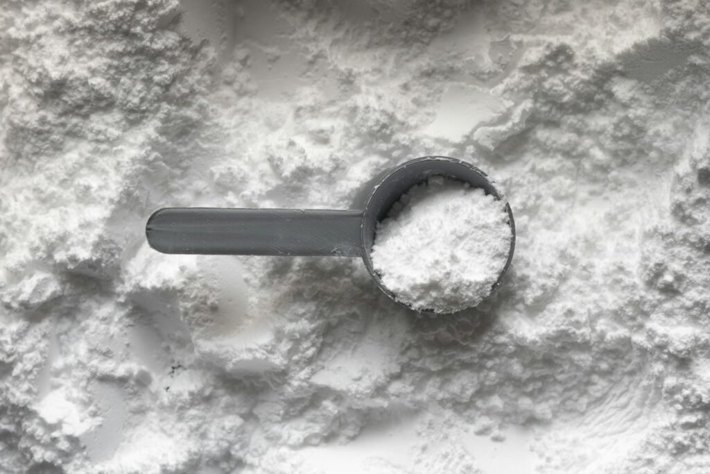 Dosador com pó branco de suplemento
