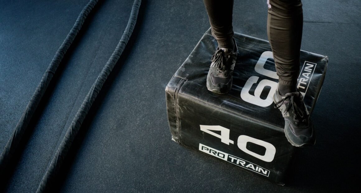 Engage in high-intensity gym workout using battle ropes and a sturdy plyo box for cardio and strength.